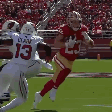 Man in Red 49ers Jersey Running With Football