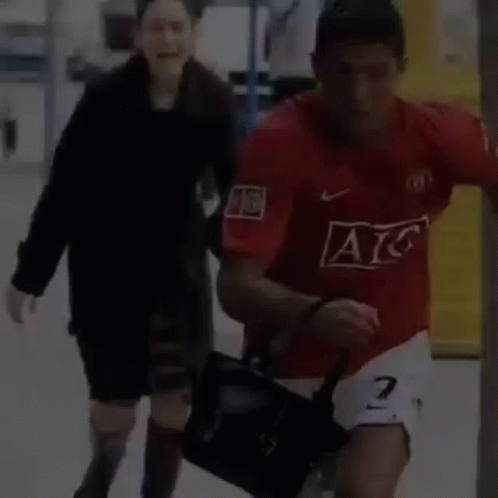 Man in Red AC Jersey Running With Woman