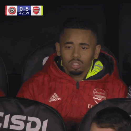 Man in Red Adidas Jacket Sitting