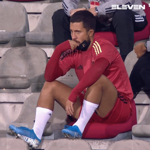 Man in Red Adidas Shirt Sitting