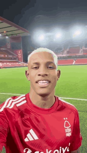 Man in Red Adidas Shirt Taking Selfie at Soccer Field