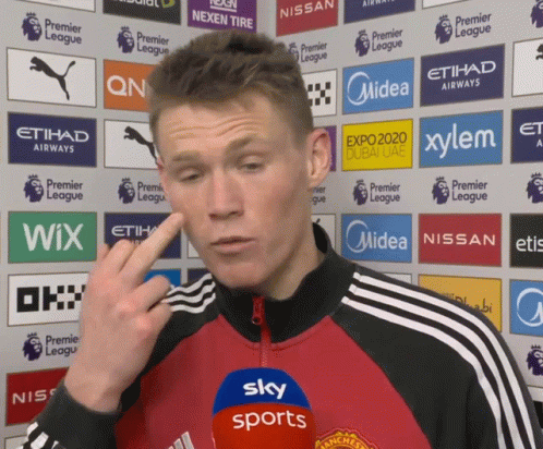 Man in Red and Black Jacket Speaking Into Sky Sports Microphone