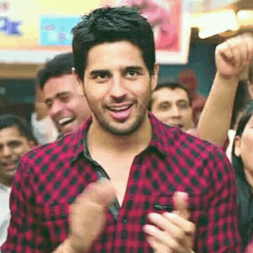 Man in Red and Black Plaid Shirt Clapping in Crowd