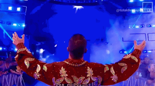 Man in Red and Gold Sweater Standing on Stage
