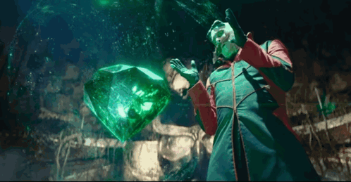 Man in Red and Green Coat Holding Large Emerald