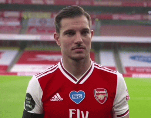 Man in Red and White Adidas Jersey With NHS Heart