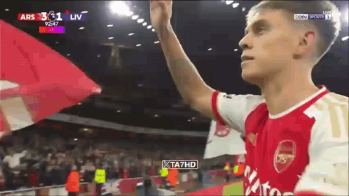 Man in Red and White Arsenal Jersey Holding Flag