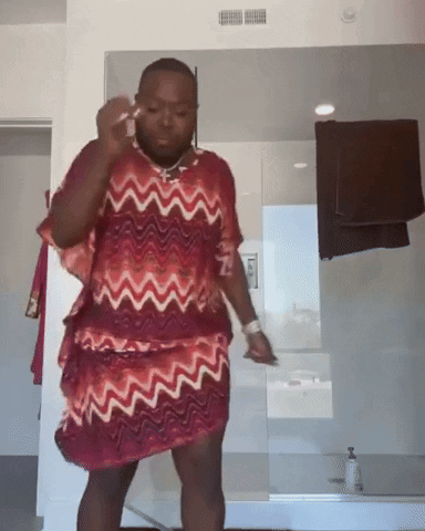 Man in Red and White Dress at Bathroom Mirror