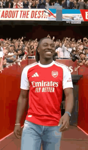 Man in Red and White Emirates Fly Better Jersey Walking Down Tunnel