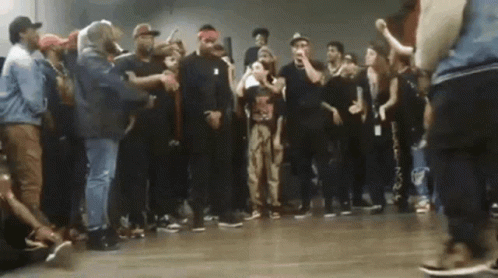 Man In Red And White Hat Dancing Beside Woman Lying On Floor GIF