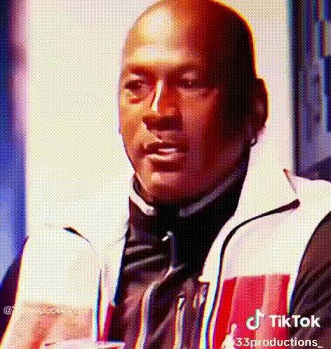 Man in Red and White Jacket Holding Drink Making Face