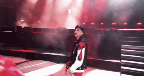 Man In Red And White Jacket On Stage Before Crowd GIF