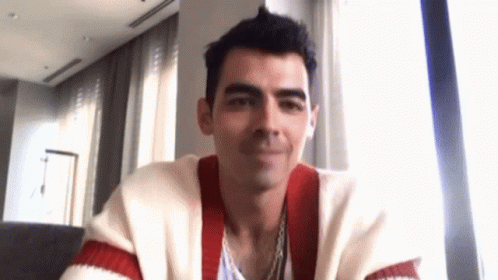 Man In Red And White Striped Sweater Sitting By Window GIF