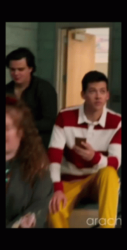 Man in Red and White Sweater Looking at Phone