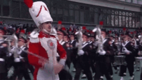 Man in Red and White Uniform Leading Band