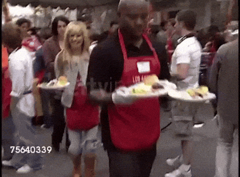 Man In Red Apron Carrying Plates Of Food GIF