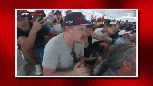Man in Red Bull Hat Sitting in Crowd