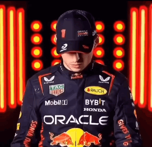 Man In Red Bull Racing Jacket And Hat In Front Of Neon Sign GIF