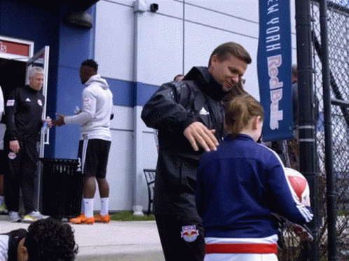Man In Red Bulls Jacket Talking To Girl GIF