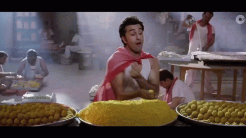 Man In Red Cape With Pile Of Food GIF