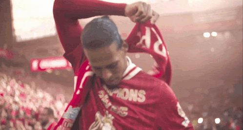 Man in Red Champions Shirt Holding Scarf