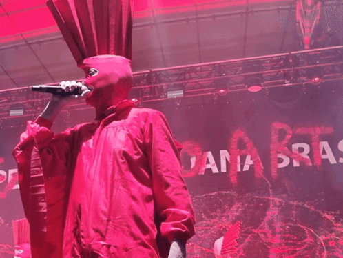 Man in Red Costume Singing Into Microphone Ana Bras