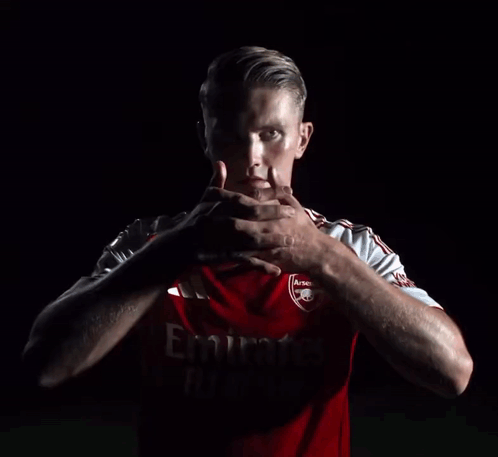Man in Red Emirates Jersey Holding Hands
