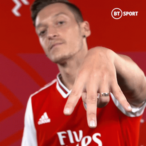 Man in Red Emirates Shirt Pointing
