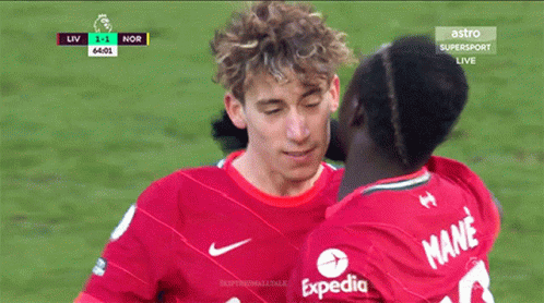 Man in Red Expedia Shirt Kissing Another Man