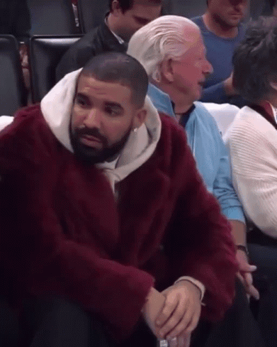 Man in Red Fur Coat Sitting in Stadium