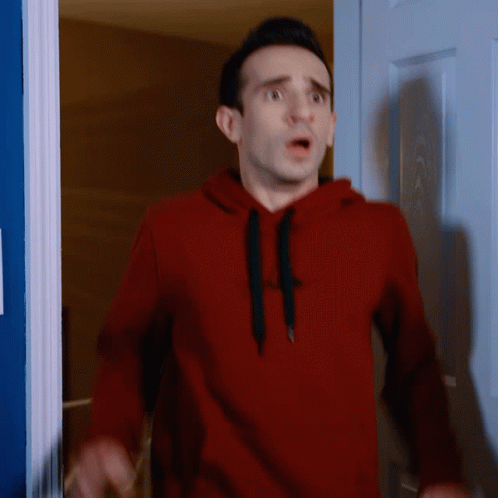 Man In Red Gap Hoodie Standing In Front Of Door GIF