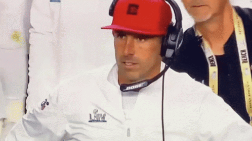 Man in Red Hat and Bose Headphones Looking