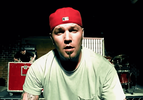 Man In Red Hat And Green Shirt With Letter G GIF