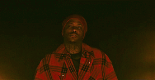 Man in Red Hat and Jacket Looking in Darkness