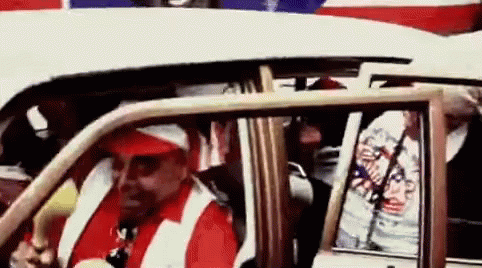 Man in Red Hat and White Vest Driving White Car