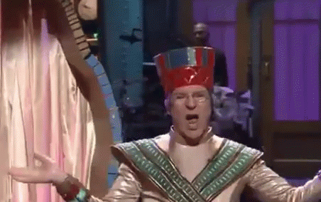 Man in Red Hat Costume Before Purple Curtain