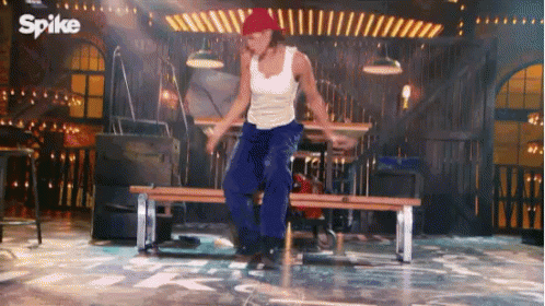 Man in Red Hat Dancing on Stage with Spike Logo