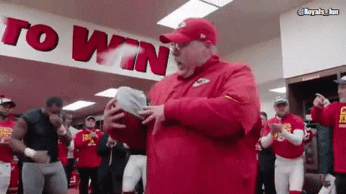 Man in Red Hat Holding Football Saying To Win
