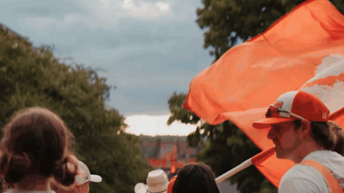 Man in Red Hat Holding Orange Flag