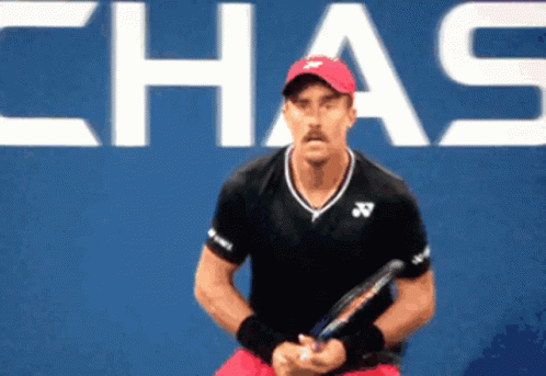 Man in Red Hat Holding Tennis Racquet Chas Sign