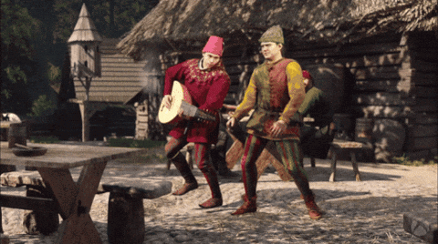 Man in Red Hat Playing Guitar With Another Man Behind