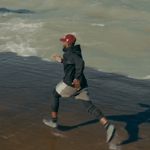 Man in Red Hat Running on Beach