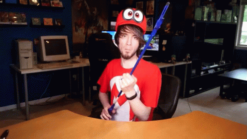 Man in Red Hat With Googly Eyes Holding Blue Stick