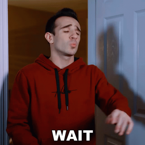 Man in Red Hoodie at Door Saying Wait