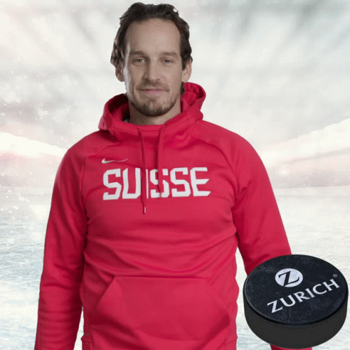 Man in Red Hoodie Saying Suisse Next to Zurich Puck