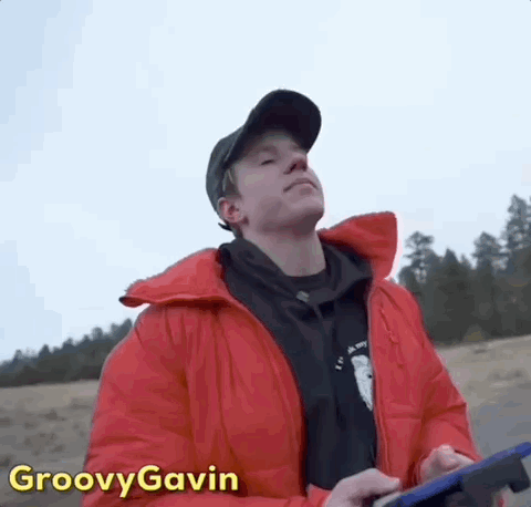 Man In Red Jacket And Black Hat Holding Tablet GIF