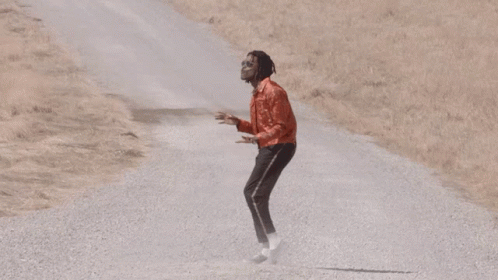 Man In Red Jacket And Black Pants On Gravel Road GIF