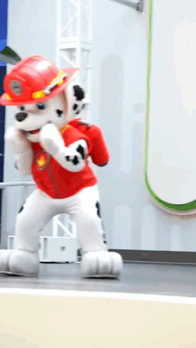 Man In Red Jacket And Red Pants Walking Down Sidewalk GIF
