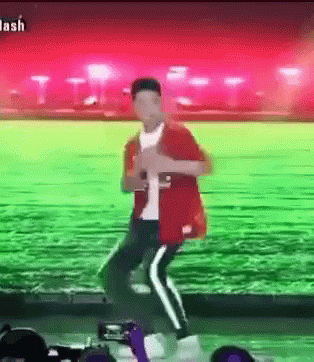 Man in Red Jacket Dancing in Green Field