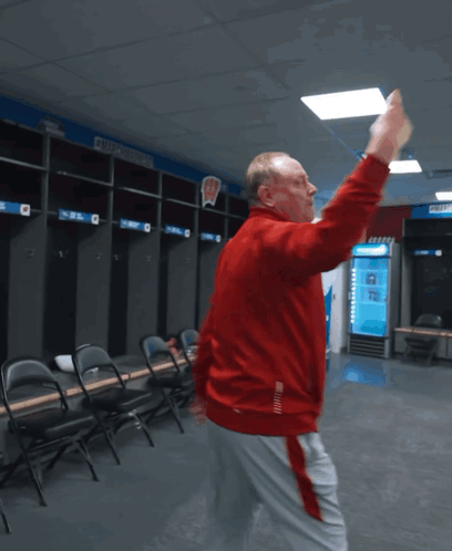 Man in Red Jacket Dancing in Locker Room With Number 2
